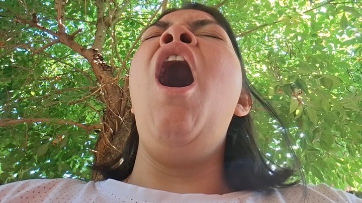 Opening her mouth in a slow yawn
