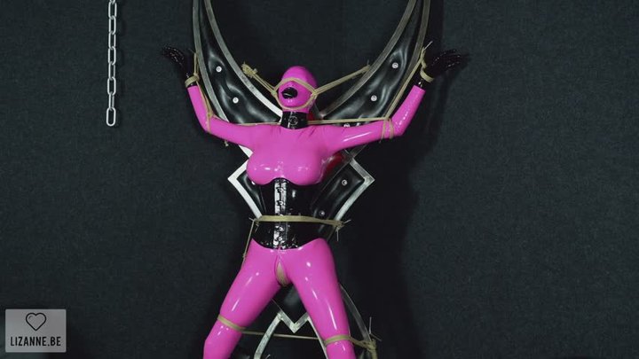 Pink doll tied to metal cross