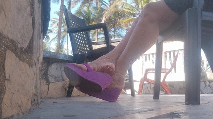 Some beautiful flip flops hanging and hitting the heel when pushed (c1)