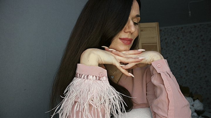 Hands with long nails under the chin