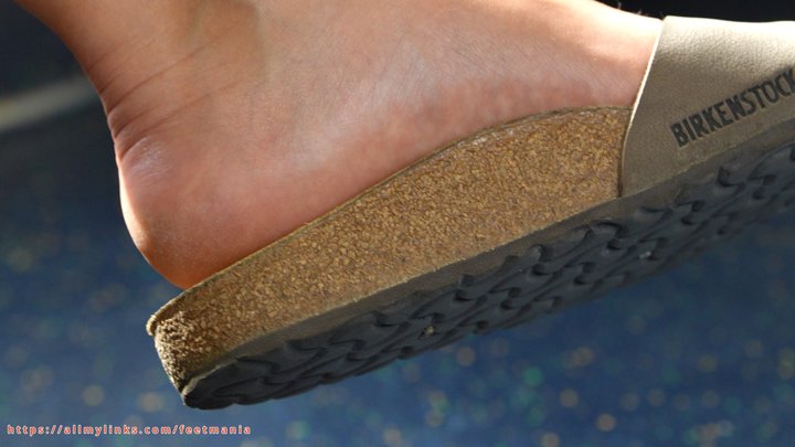 Birkenstock slippers and beauty feet on train, feet and soles close-up. Ignoring