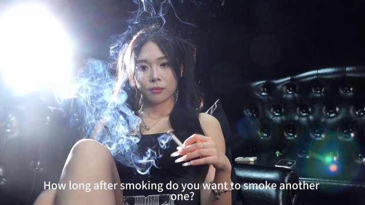 A young woman in a black dress lies on the sofa, exhaling smoke elegantly chen1 