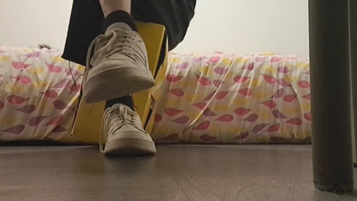 Sitting and crushing a big cardboard box with Adidas sneakers