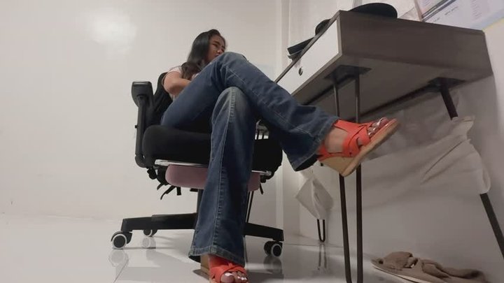 Dangling her feet under the table wearing wedge heels sandals