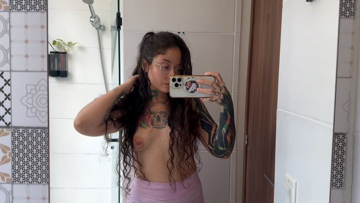Tattooed girl with a split tongue smells her hairy armpits after working out.