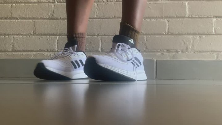 Big ebony feet takes off sneakers and socks after running errands