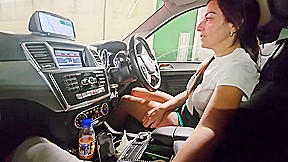 While our car is immobilized in freeway congestion, she grasps my penis in her h
